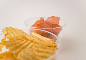 Potato and meat chips in clear glasses. Corrugated potato chips in glass cups. Beer snack.