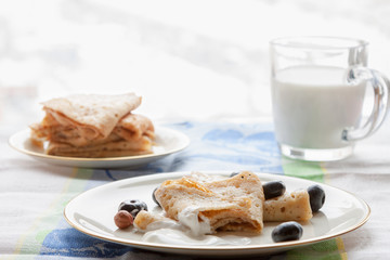 gluten free homemade pancakes plate with sour cream and glass of milk breakfast on white kitchen table snow winter window background copy space