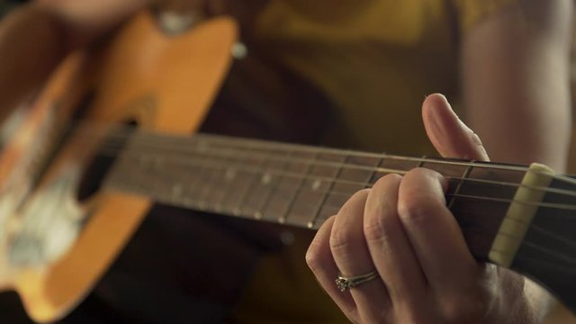 Fingers over fretboard of guitar