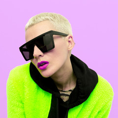 Stylish blonde girl with short hair and trendy sunglasses. Fashion clubbing style