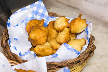 Pettole, Italian donuts fried in oil on a paper napkin in a basket. Made in Puglia. Served as an...