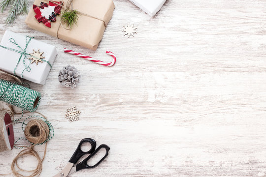 Christmas background with handmade gift boxes and decorations on white wooden board. Creative Flat layout and top view composition with border and copy space design