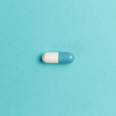 Pharmaceutical medicine pills, tablets and capsules on aqua background. Top view. Flat lay. Copy space. Medicine concepts. Minimalistic abstract concept. AI Aqua - color of the year 2021