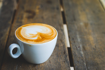 close up modern hot black coffee the cappuccino on wood background with coffee bubble foam pattern and texture in white cup looking and feel so delicious on glasses table in coffee shop.