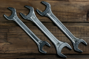 set of wrenches on a wooden background, place for an inscription	