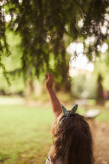 Fresh branch of spruce in the hands of a child. Defocus in the frame and natural background. Photo on the nature