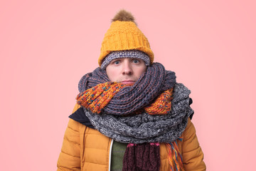 Handsome caucasian funny man in several hats and scarfs.