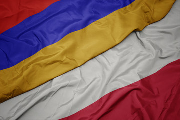 waving colorful flag of poland and national flag of armenia.