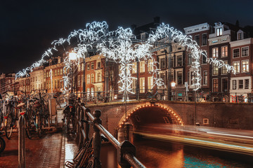Giant spider of white light above a bridge over the Herengracht in the old town of Amsterdam