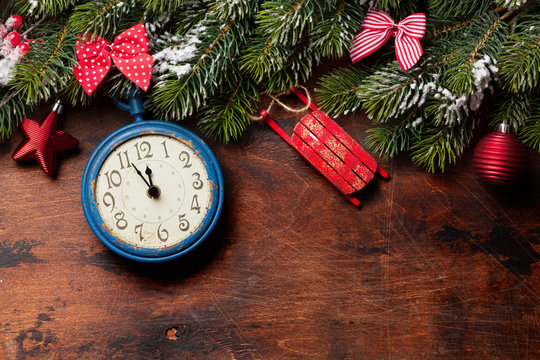 Christmas fir tree and alarm clock over old wood