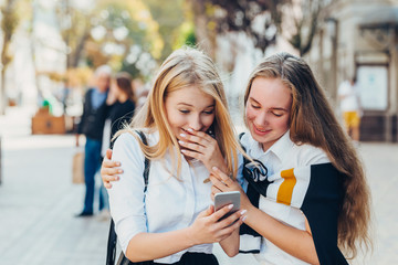 Happy brightful positive moments of two stylish girls hugging on street in city. Closeup portrait funny joyful attarctive young girls having fun, smiling, lovely moments, best friends.