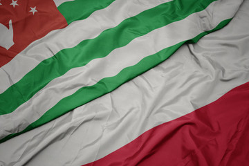waving colorful flag of poland and national flag of abkhazia.