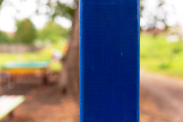 Wooden, painted blue, oil paint pole closeup.