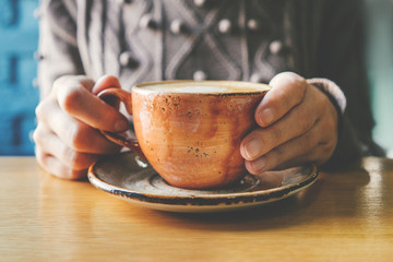 Woman's hand holding a cup of coffee.