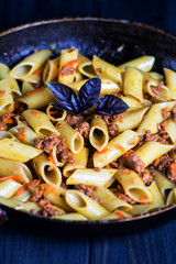 stewed macaroni with meat, carrots, onions and spices in a pan