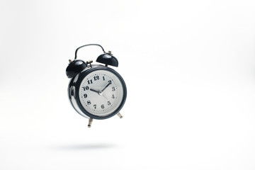 Alarm clock falling on white background.