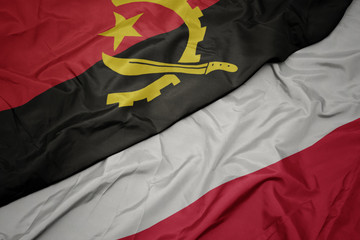 waving colorful flag of poland and national flag of angola.