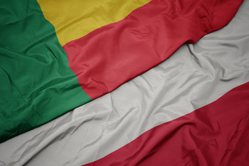 waving colorful flag of poland and national flag of benin.