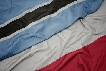 waving colorful flag of poland and national flag of botswana.
