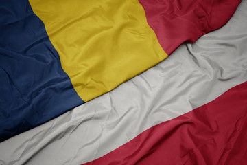waving colorful flag of poland and national flag of chad.