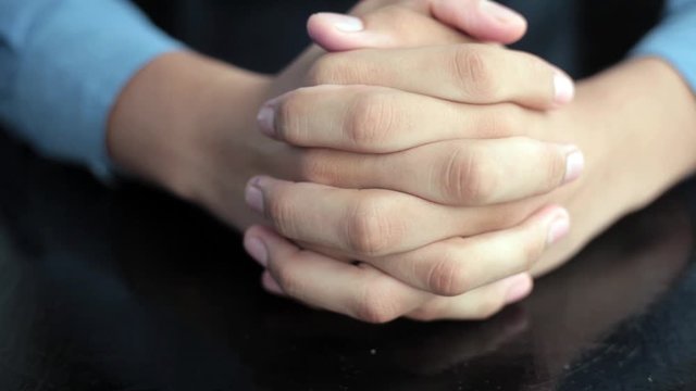 Pair of hands coming clasping and setting them on black table feeling relaxed.HD video.