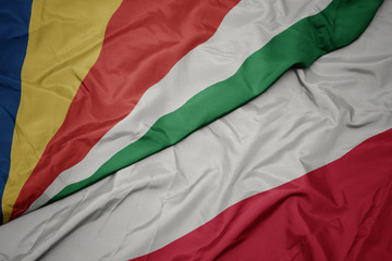 waving colorful flag of poland and national flag of seychelles.