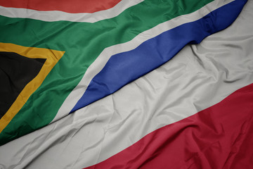 waving colorful flag of poland and national flag of south africa.