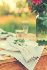 Table with plate is decorated with linen napkins and green leaf