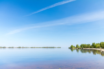 Colorful spring landscape on river with beautiful clouds in the sky