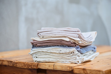 A stack of linen textiles on a wooden table