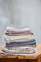 A stack of linen textiles on a wooden table