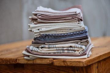 A stack of linen textiles on a wooden table