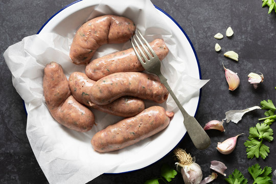 Raw beef sausages pricked with a fork.