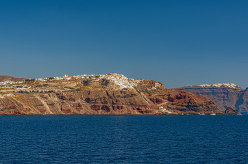 Fototapeta premium Vista panoramica sul villaggio di Oia abbarbicato sulla caldera, isola di Santorini GR 