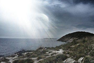 The sea is dark, monsoons and the light of hope shines down.