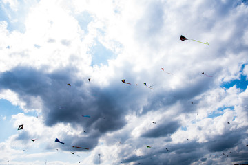 Group of Kites flying in the air against clouds