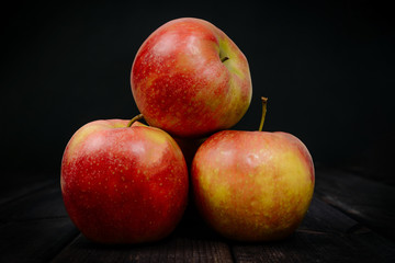 Red apples on a dark wooden table. The concept of eating fruit, eating meals with vitamins. Taking care of yourself, diet. Healthy food, apples.