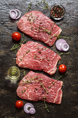 meat beef marbled with spices and herbs on a dark background