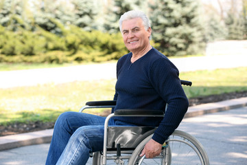 Senior man in wheelchair at park on sunny day