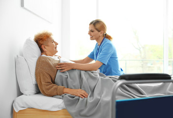 Obraz premium Nurse in uniform assisting elderly woman indoors