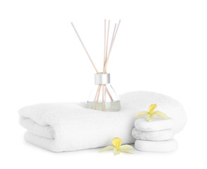 Fototapeta na wymiar Towel, air freshener, flowers and spa stones isolated on white
