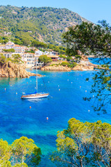 Sailing boat on blue azure sea in Cala Fornells bay, Costa Brava, Catalonia, Spain