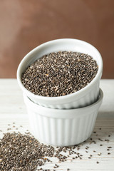 Ceramic sauce boats with chia on wooden background, copy space