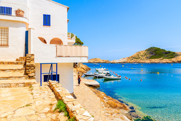 Unidentified young woman walking along beautiful coast in Sa Tuna village, Costa Brava, Catalonia, Spain