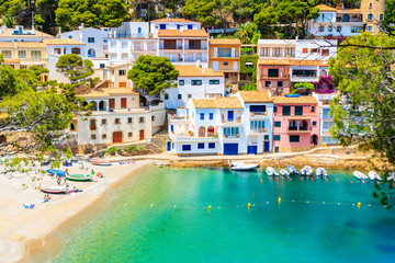 View of beach in Sa Tuna fishing village with colorful houses on shore, Costa Brava, Catalonia, Spain