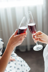 group of people touch champagne glasses and cocktails