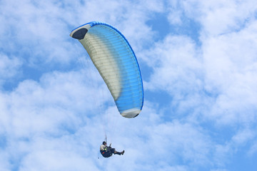 Paraglider flying wing in a blue sky