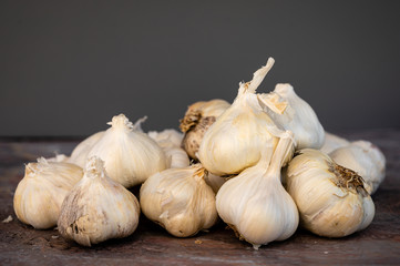 Group of garlic bulbs on a textured surface and gray background
