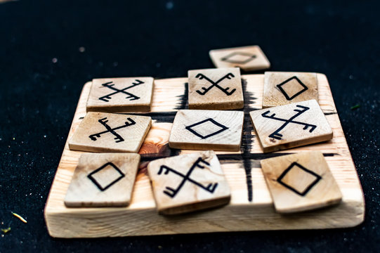 Closeup of wooden tic-tac-toe or oughts and crosses game made in pagan design. Criss cross board game.
