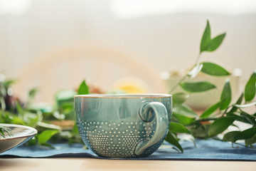 Cup with saucer on table with leaf
